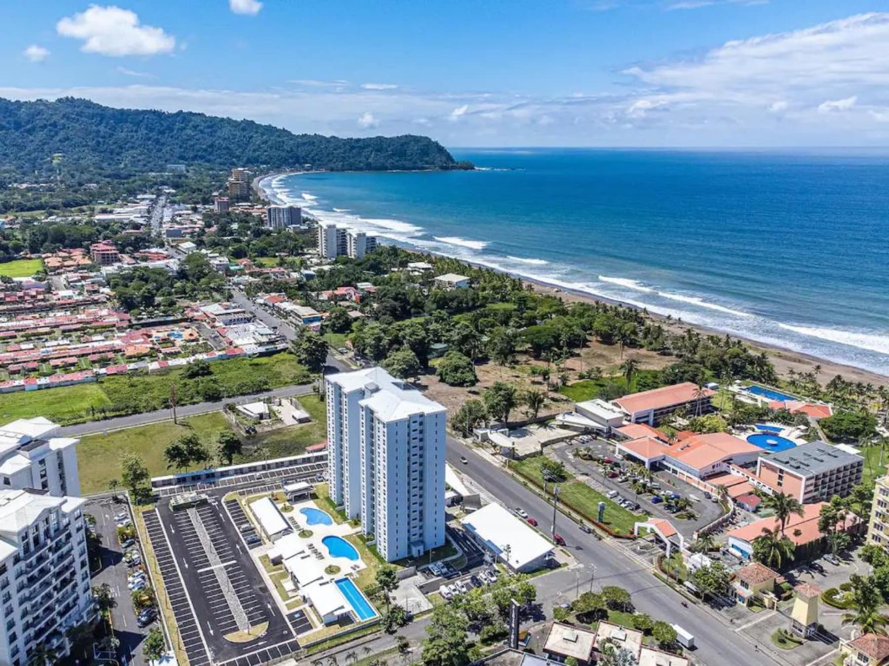 Aerial view of the Viva Jaco buildings, pools and parking area in Barrio Santa Lucía, at the edge of Jacó.